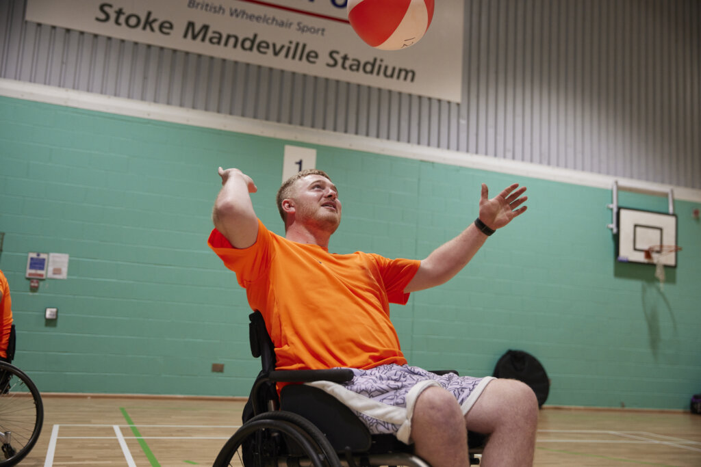 Recently paralysed male trying volleyball at the 2023 Inter Spinal Unit Games