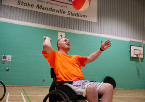 Recently paralysed male trying volleyball at the 2023 Inter Spinal Unit Games