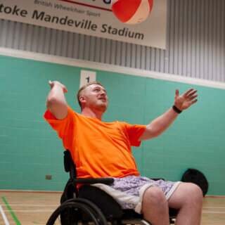 Recently paralysed male trying volleyball at the 2023 Inter Spinal Unit Games