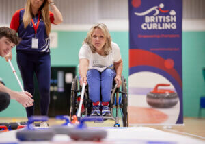 Angie Malone MBE demonstrating wheelchair curling at Stoke Mandeville Stadium