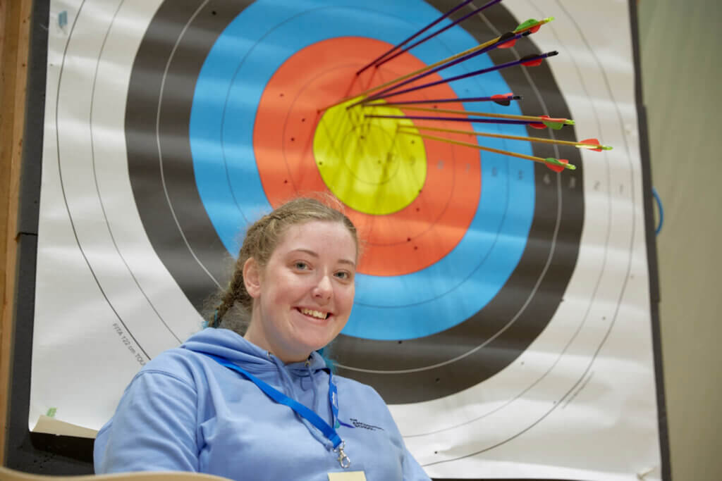 young athlete next to an archery target