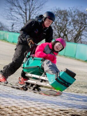 Young wheelchair user on a dry slope