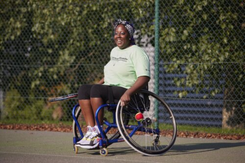 Helen preparing to serve in a wheelchair tennis game