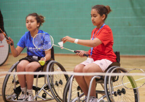 Young Wheelchair badminton players serving