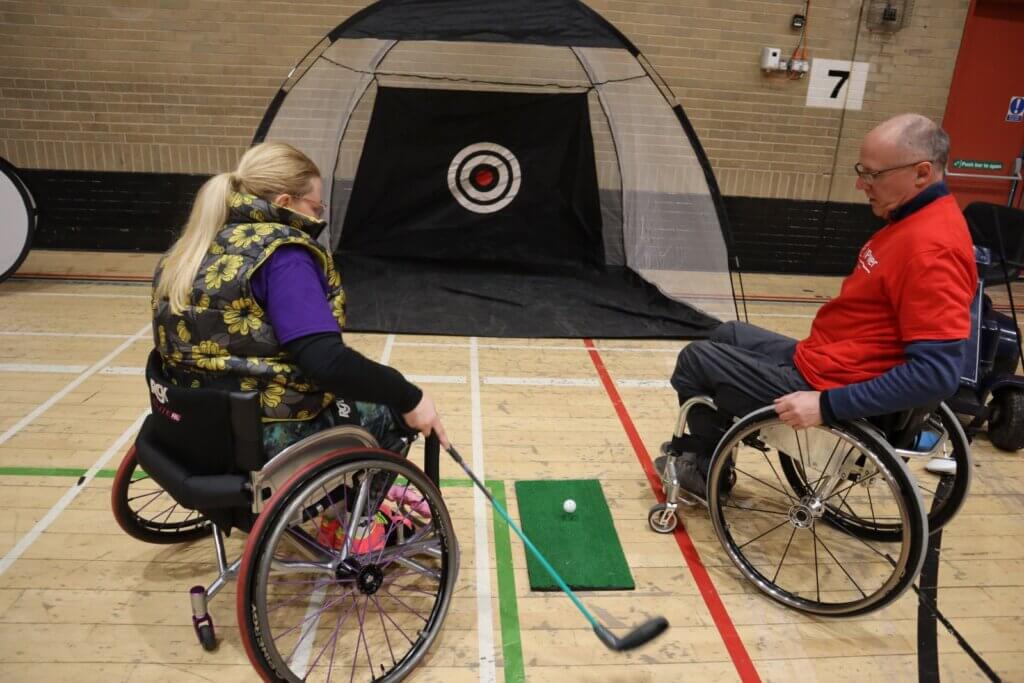 Wheelchair users playing handi-golf