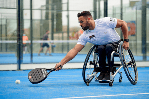 Male in white tshirt playing padel - reaching