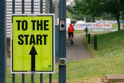 Tour de Vale Bike Ride - to the start sign showing with cyclists in the background